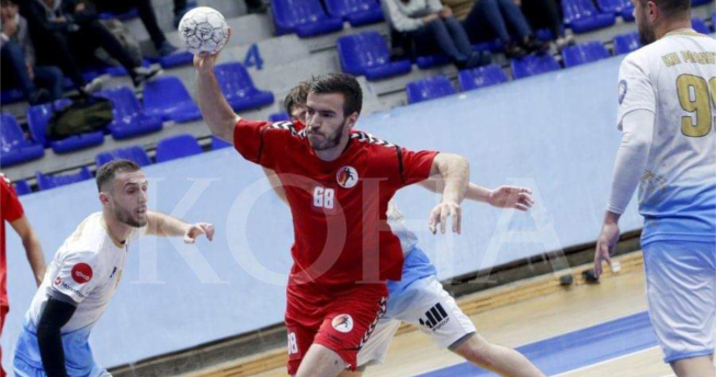 Lojtari po gjuan topin kurse tre lojtarë kundërshtarë po mundohen t'a ndalojnë.