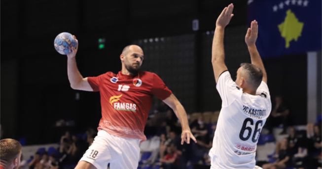 Një lojtarë është hedhur lartë për të gjuajtur me top, kurse kundërshtari i tij tenton ta bllokojë me duart lartë.