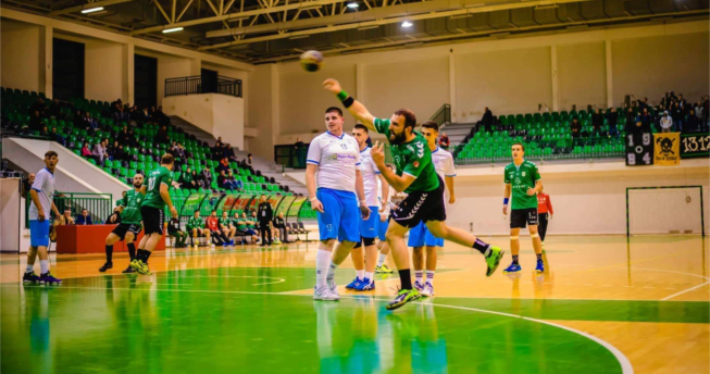 Një lojtarë ka gjuajtur topin për të shënuar dhe mbrapa tij janë lojtarët e të dy ekipeve.