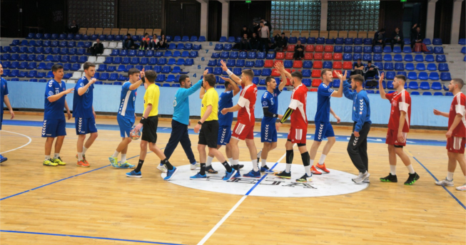 Në foto shihen gjyqtarët dhe hendbollistët e të dy ekipeve duke u përshëndetur me njëri-tjetrin para fillimit të ndeshjes.