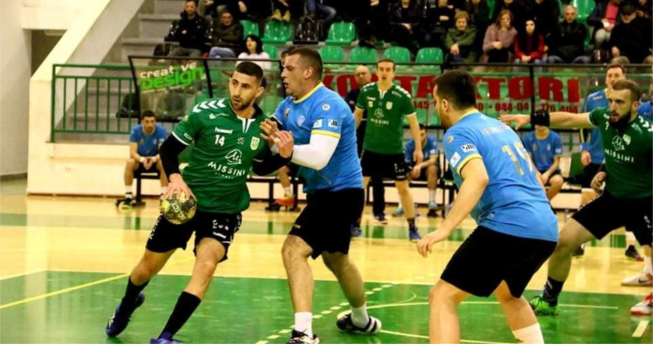 Lojtari ka topin në dorë kurse kundërshtari po mundohet ta ndalojë atë duke e kapur për fanellë.